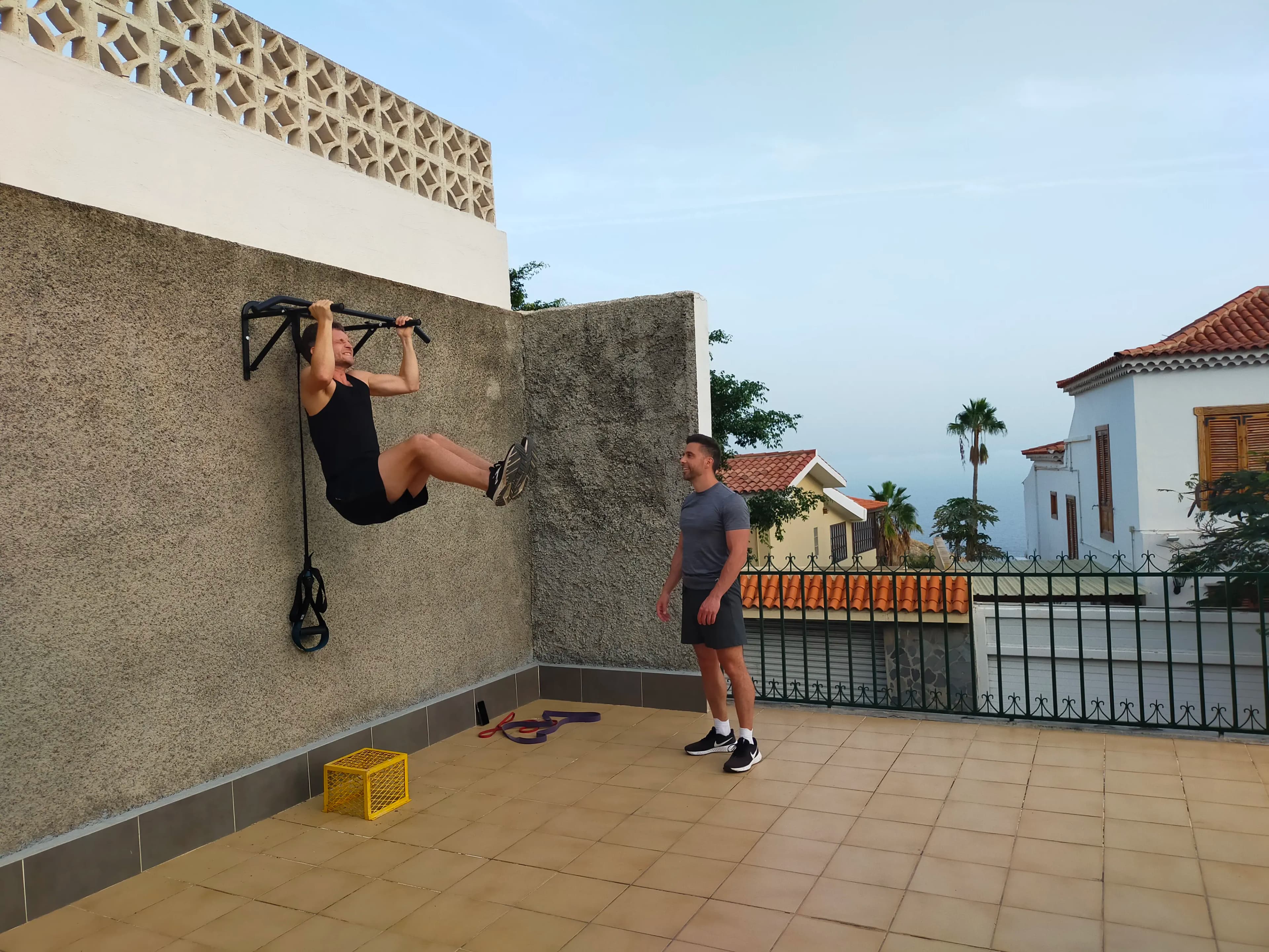Outdoor fitness terrace with ping-pong, TRX, and a stationary bike.
